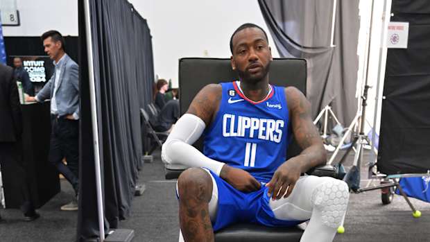 John Wall sits in front of sneaker collection.